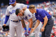 Los Angeles Dodgers manager Dave Roberts, left, comforts David Peralta, center, as he is taken off the field after being hit by a pitch during the second inning of a baseball game against the Washington Nationals at Nationals Park, Sunday, Sept. 10, 2023, in Washington. (AP Photo/Andrew Harnik)