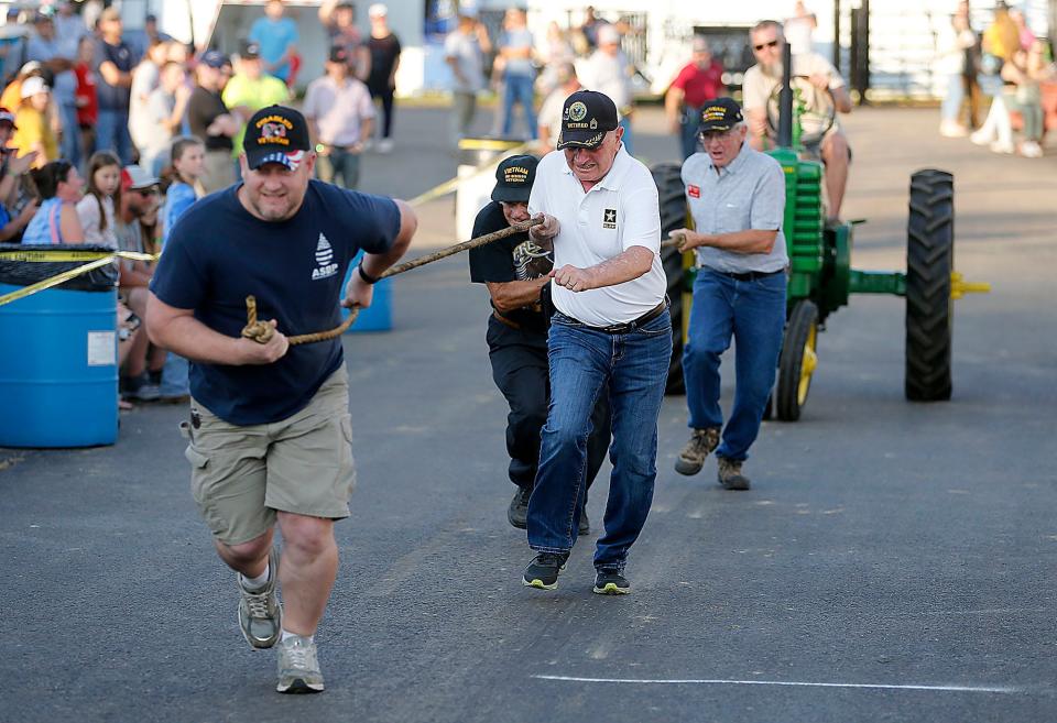 John Davenport, Randy Stillings, Larry Repp and Arden Fitch compete in the human antique tractor pull at the Ashland County Fair on Monday, Sept. 19, 2022. TOM E. PUSKAR/ASHLAND TIMES-GAZETTE