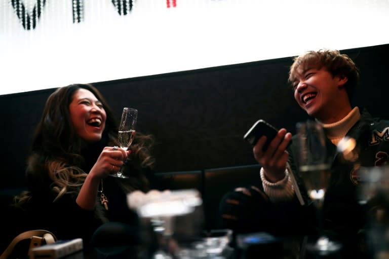 Businesswoman Aki Nitta shares a joke with her host Shia at a club in Tokyo's Kabukicho red-light district