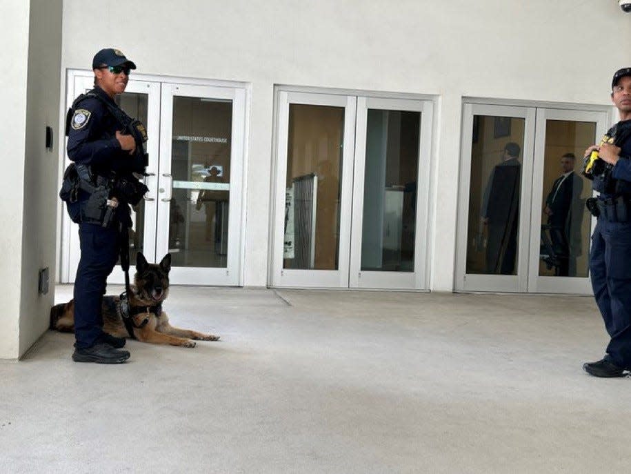 Federal Protective Services officers and a K9 guard the from entrance to the Alto Lee Adams Sr. U.S. Courthouse in Fort Pierce, while former President Donald Trump is inside in a closed hearing about classified documents in his criminal case involving the alleged mishandling of those documents..