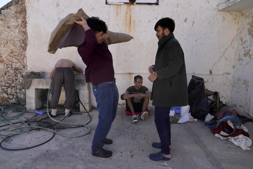 Migrants, most of them from Afghanistan, gather at an old school used as a temporary shelter on the island of Kythira, southern Greece, Thursday, Oct. 6, 2022. Bodies floated amid splintered wreckage in the wind-tossed waters off a Greek island Thursday as the death toll from the separate sinkings of two migrant boats rose to 22, with many still missing. (AP Photo/Thanassis Stavrakis)