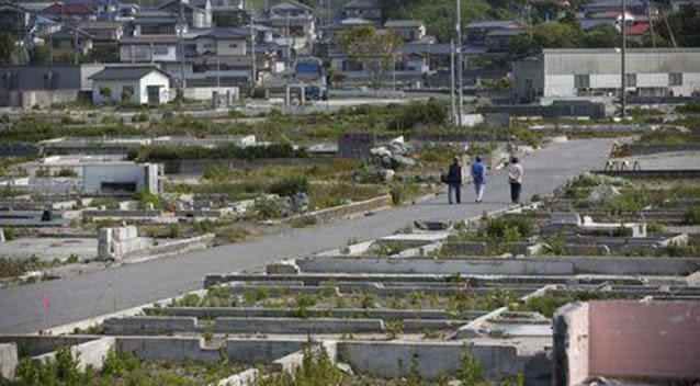 Local residents walk along a Iwaki street devastated by the tsunami and earthquake. Picture: Reuters