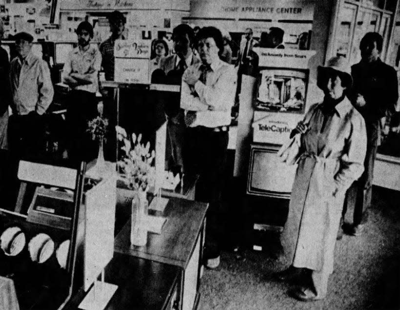 Shoppers and employees at Sears in Bridgewater gather around a television display area to watch reports on the attempted assassination of President Ronald Reagan.