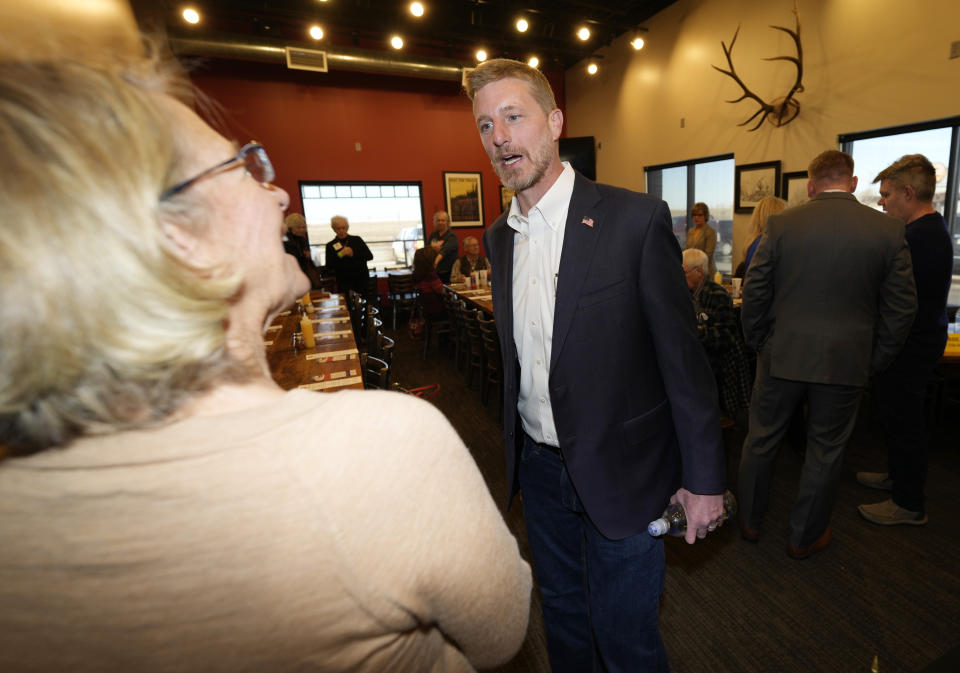 Candidate for the Colorado Republican Party chair position Erik Aadland, center, talks with a well-wisher before a debate for the state Republican Party leadership position Saturday, Feb. 25, 2023, in a pizza restaurant in Hudson, Colo. (AP Photo/David Zalubowski)