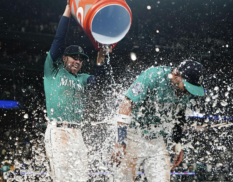 Seattle Mariners catcher Tom Murphy douses Jose Caballero as they celebrate a 7-5 win over the against the Houston Astros in a baseball game Saturday, May 6, 2023, in Seattle. (AP Photo/Lindsey Wasson)