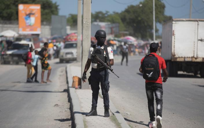 National police officers patrol an intersection in Port-au-Prince, Haiti