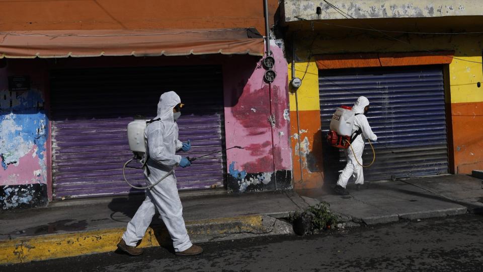 Coronavirus-Pandemie: In Mexiko-Stadt sprühen Arbeiter eine Desinfektionslösung auf die Straße.