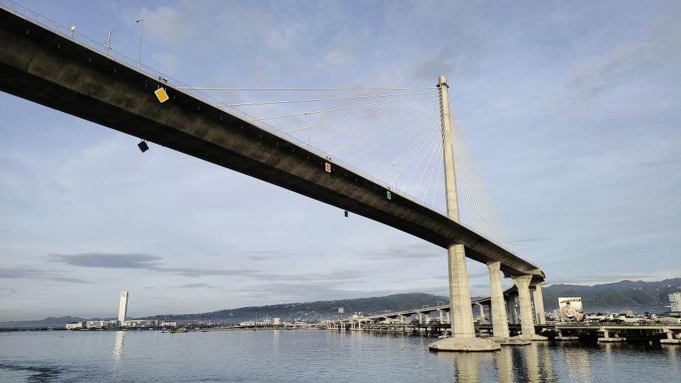 A bridge over water with a city in the background