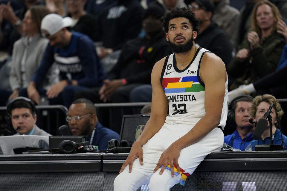 Minnesota Timberwolves center Karl-Anthony Towns watches play from the sideline during the first half of an NBA basketball game against the Portland Trail Blazers, Sunday, April 2, 2023, in Minneapolis. (AP Photo/Abbie Parr)