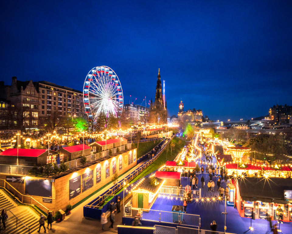 A view over Edinburgh's illuminated Christmas attractions in Princes Street Gardens, with the Scott Monument and North Bridge on the horizon.