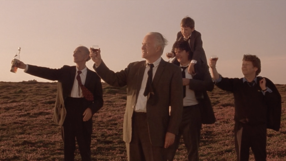 A group of people toast atop a cliff in Waking Ned Devine