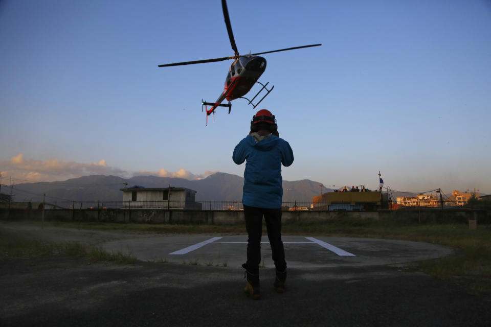 A helicopter carrying bodies of those killed in Gurja Himal mountain arrives at the Teaching hospital in Kathmandu, Nepal, Sunday, Oct. 14, 2018. Rescuers retrieved the bodies of five South Korean climbers and their four Nepalese guides from Gurja Himal mountain, where they were killed when their base camp was swept by a strong storm. (AP Photo/Niranjan Shrestha)