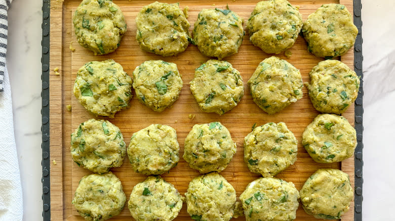 uncooked pea patties on wood board