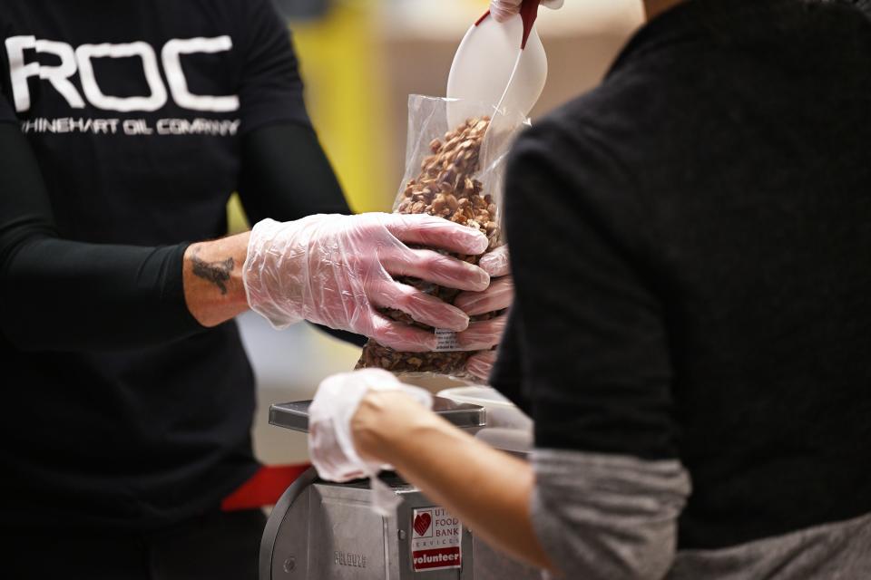 Volunteers assemble and fill bags of nuts at the Utah Food Bank and talk about the products and items they have for those that need them, at their South Salt Lake warehouses on Thursday, Dec. 28, 2023. | Scott G Winterton, Deseret News