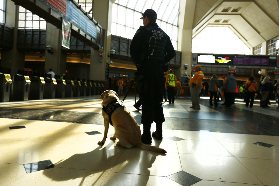 A police officer and his dog keep watch at the Secaucus Junction, Sunday, Feb. 2, 2014, in Secaucus, N.J. The Seattle Seahawks are scheduled to play the Denver Broncos in the NFL Super Bowl XLVIII football game on Sunday, earning MetLife Stadium in East Rutherford, N.J. (AP Photo/morry gash)