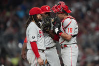 Philadelphia Phillies' Freddy Galvis, left,, Hector Neris (50) and catcher J.T. Realmuto (10) meet on the mound during the eighth inning of a baseball game against the Atlanta Braves Tuesday, Sept. 28, 2021, in Atlanta. (AP Photo/John Bazemore)
