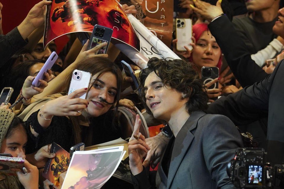 El actor Timothee Chalamet posa para un selfie mientras firma autógrafos durante un evento para promocionar el estreno de la película "Duna: Parte dos", en la Ciudad de México, el 6 de febrero de 2024. (AP Foto/Marco Ugarte)