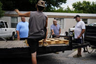 Daniel Guess, left, Cameron Parker, center, Larry Guess, center right, and Jerry Gulley, right, talk outside of Guess' trailer home on Thursday, June 23, 2022, in Athens, Ala. David Guess, Larry's son, was killed by gun violence in March. His killing drew little attention outside the rural stretch of northern Alabama where Guess grew up and later worked as a mechanic and truck driver, though his death shattered many lives. (AP Photo/Brynn Anderson)