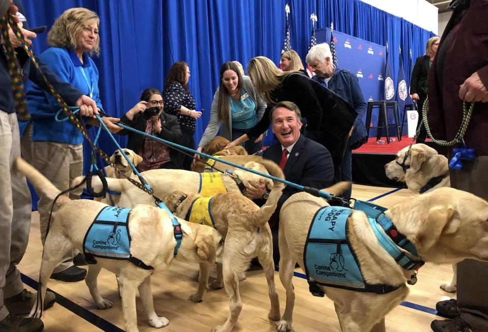 Governor Glenn Youngkin and First Lady Suzanne S. Youngkin pet service dogs at the Petersburg Family YMCA on Friday, December 1.