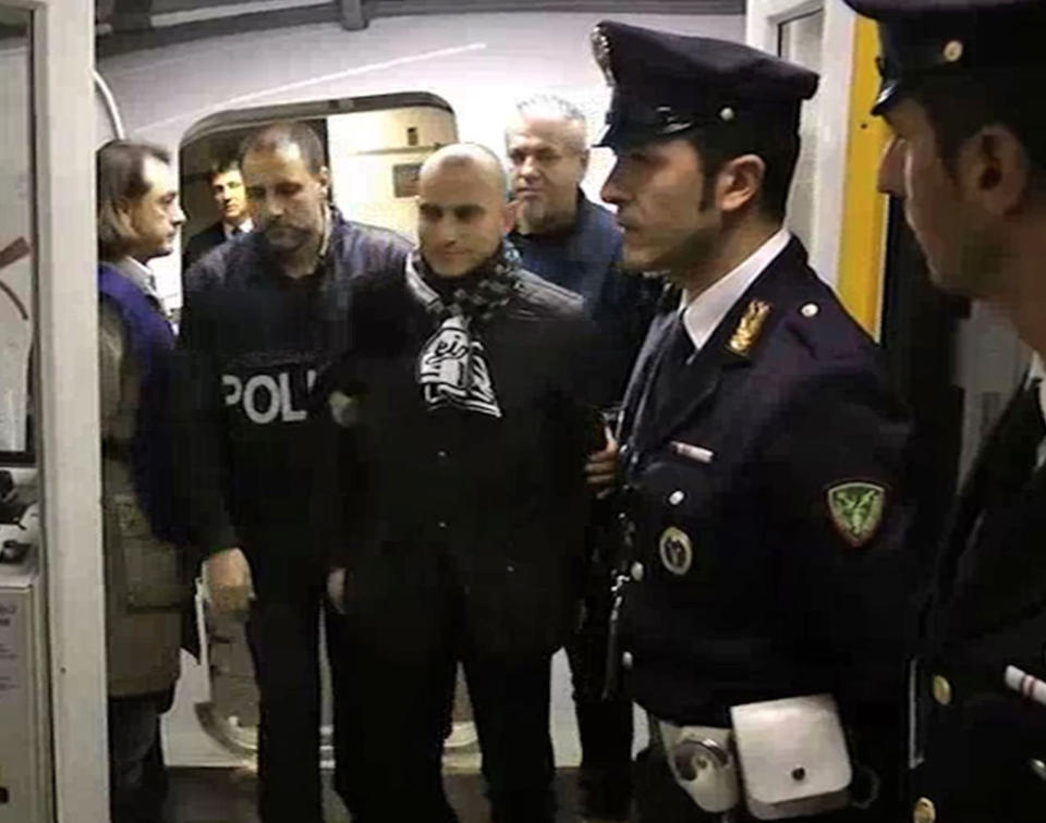 This image take from a video released by the Italian Police, Serbian footballer Almir Gegic, who has been wanted since June 2011 for alleged involvement in a widespread match-fixing case, is escorted by police after he arrived at the Malpensa airport in the outskirts of Milan, Italy, Monday evening, Nov. 26, 2012. After more than a year on the run, Gegic turned himself in and was brought to a jail in Cremona, where prosecutor Roberto Di Martino's match-fixing inquiry is based. More than 50 people have been arrested so far and more than 100 are under investigation. (AP Photo/Italian Police, HO)
