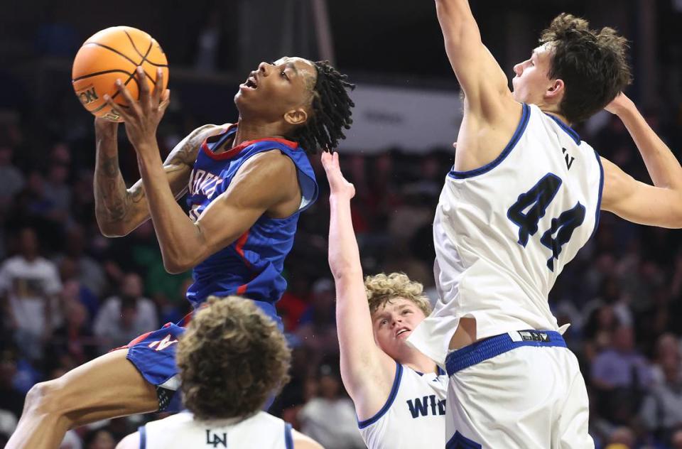 North Meck’s Isaiah Evans, left, drives to the basket past the Lake Norman defense and 6-foot-10 power forward Trent Steinour (44) during fourth-quarter action in the NCHSAA 5A Regional Championship on Thursday, March 14, 2024 at Lawrence Joel Veterans Memorial Coliseum in Winston-Salem, NC. North Meck defeated Lake Norman 65-61 in overtime to move into Saturday’s final against New Hanover. JEFF SINER/jsiner@charlotteobserver.com