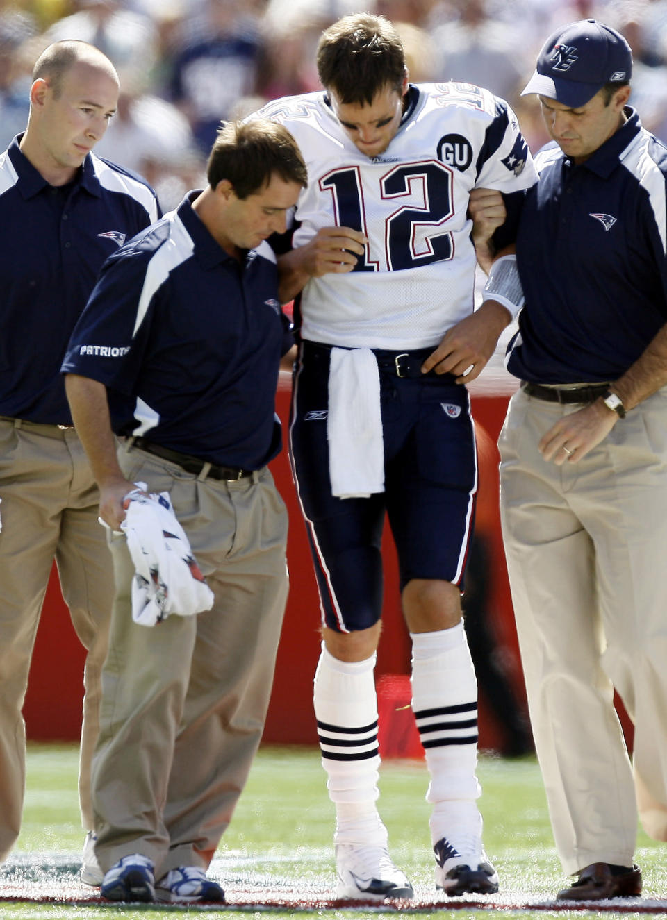 In this Sept. 7, 2008, file photo, New England Patriots quarterback Tom Brady (12) is helped off the field by medical personnel after he was hit while throwing the ball during the first quarter of their football game against the Kansas City Chiefs at Gillette Stadium in Foxborough, Mass. The tackle by Kansas City Chiefs safety Bernard Pollard was legal, though the NFL has since outlawed the type of lunge that hurt Brady. (AP Photo/Winslow Townson,file)