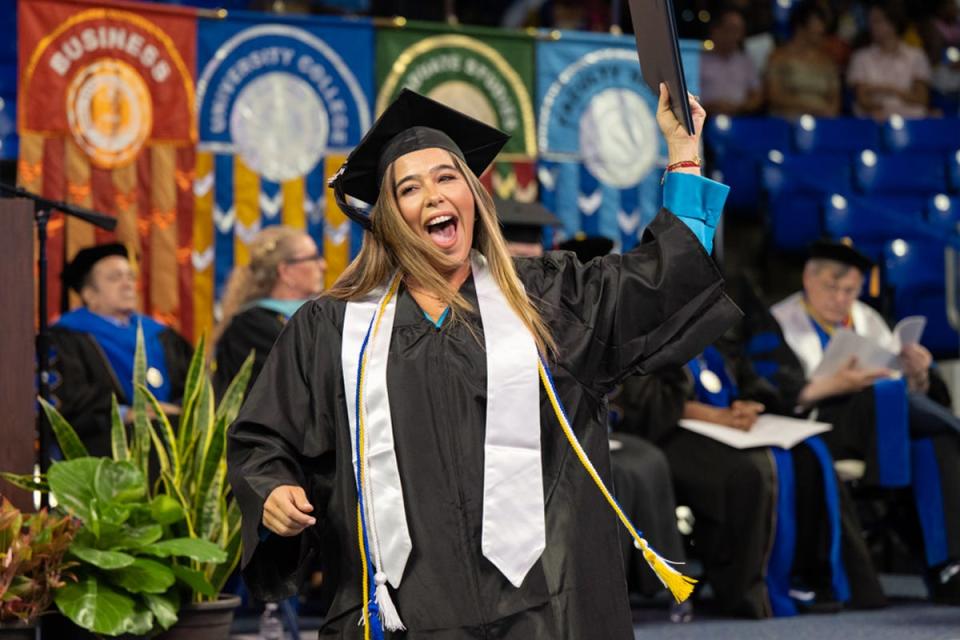 MTSU graduate Laura Esther Espine raises her hard-earned degree skyward and shouts happily after crossing the stage at Murphy Center Aug. 6 at the university's summer commencement ceremony. MTSU presented 857 degrees to undergrad and graduate students during the event, which concludes the university's 111th academic year.