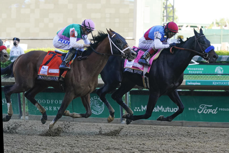 FILE - In this May 1, 2021, file photo, Medina Spirit, ridden by John Velazquez, right, leads Mandaloun, and jockey Florent Geroux, to the wire in the 147th running of the Kentucky Derby horse race at Churchill Downs in Louisville, Ky. Medina Spirit was stripped of the victory in last year’s Kentucky Derby and Mandaloun was declared the winner in a ruling by state racing stewards on Monday, Feb. 21, 2022. (AP Photo/Darron Cummings, File)