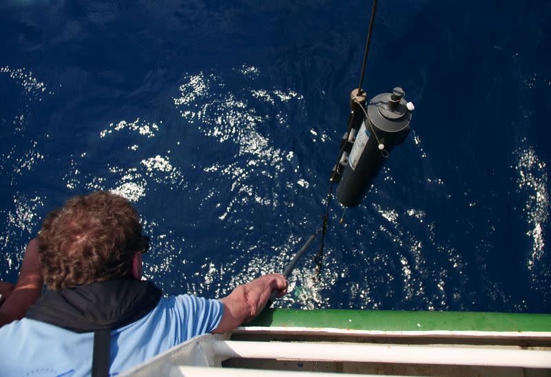 Marine biologist Tim Lewis retrieves a Niskin Water Sampling Bottle at the Saya de Malha Bank