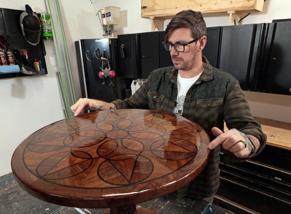 Jonny Lambert talks Jan. 29 about one of the creations at his shop.