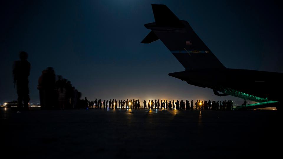 A U.S. Air Force crew assigned to the 816th Expeditionary Airlift Squadron prepares to load evacuees aboard a C-17 Globemaster III aircraft  at Hamid Karzai International Airport in Kabul, Afghanistan, on Aug. 21.