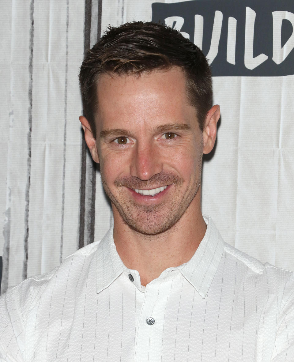 Jason smiling at an event, wearing a white button-up shirt