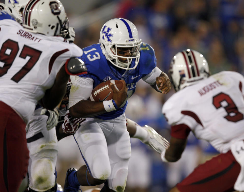 Jalen Whitlow #13 of the Kentucky Wildcats battles pressure from Akeem Auguste #3 and J.T. Surratt #97 of the South Carolina Gamecocks at Commonwealth Stadium on September 29, 2012 in Lexington, Kentucky. (Photo by John Sommers II/Getty Images)