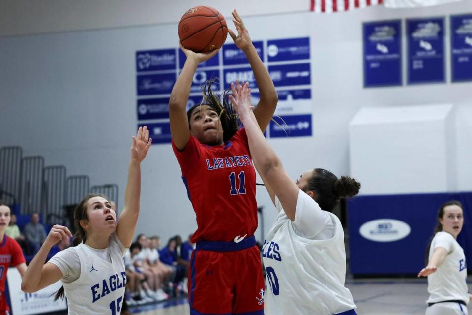 Lafayette’s Isabelle Combs (11) shoots the ball in between Lexington Christian’s Chapel Brown, left, and Jeriko Castle during their game at LCA on Friday. Silas Walker/swalker@herald-leader.com