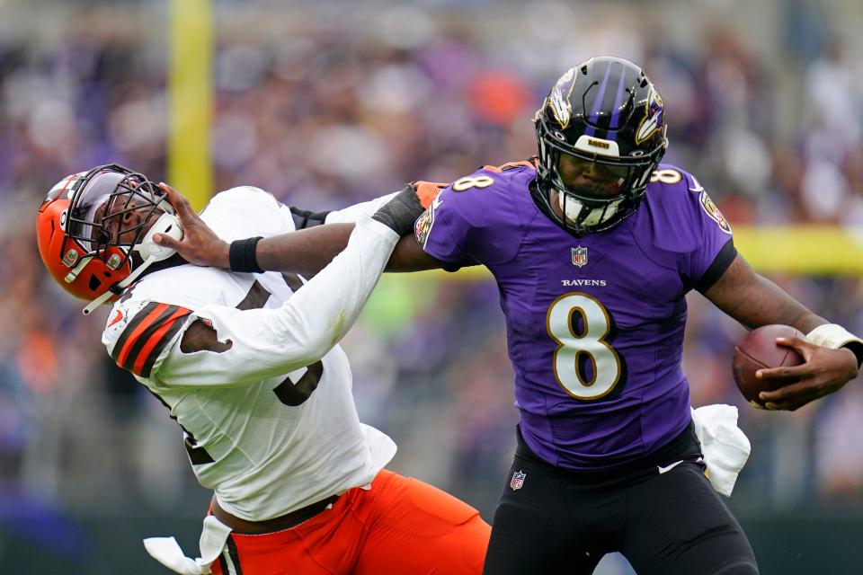 Baltimore Ravens quarterback Lamar Jackson (8) tries to fend off Cleveland Browns linebacker Deion Jones (54) in the second half of an NFL football game, Sunday, Oct. 23, 2022, in Baltimore. (AP Photo/Julio Cortez)