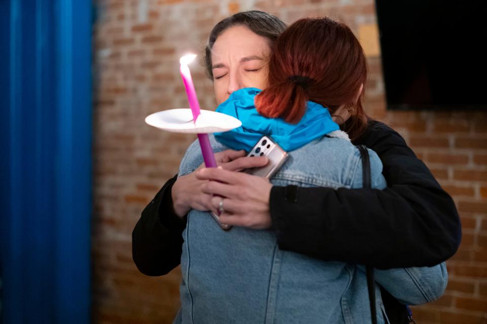 Kate Bierman, facing camera, hugs Marie Driskill during a candlelight vigil for Shannon Hanchett.