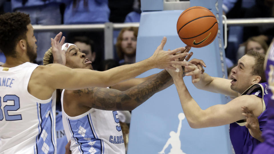 North Carolina forward Pete Nance (32) and forward Armando Bacot (5) battle James Madison guard Noah Freidel, right, for a rebound during the first half of an NCAA college basketball game Sunday, Nov. 20, 2022, in Chapel Hill, N.C. (AP Photo/Chris Seward)