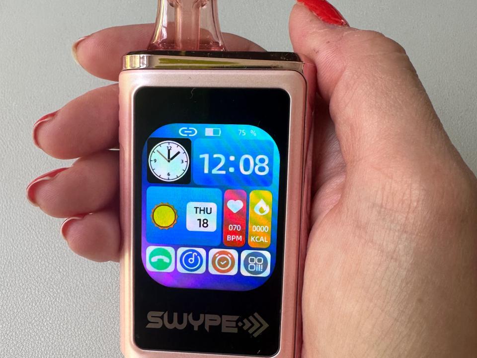 A Swype vape phone device sits in my hand with a view of its home screen.