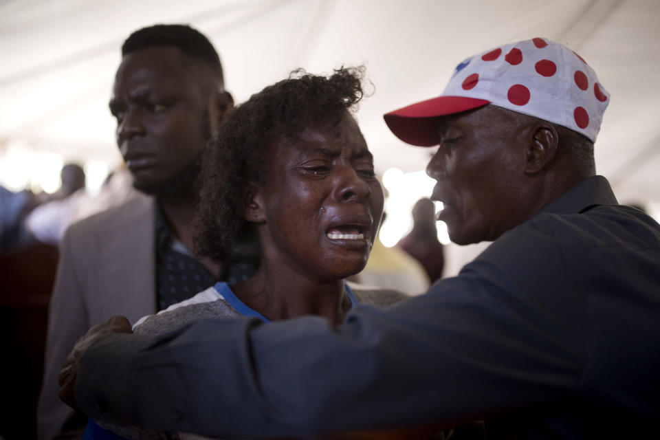 In this Dec. 13, 2018 photo, Morelle Lendor, who survived the La Saline massacre and lost a friend, cries during a memorial ceremony for the victims in Port-au-Prince, Haiti. The 33-year-old street vendor said she was hiding in her home on Nov. 13 with a friend named Wuanito when men knocked on the door who she recognized them as gangsters from an adjoining neighborhood. They pulled Wuanito from the shack and killed him with a single shot, Lendor explained. (AP Photo/Dieu Nalio Chery)