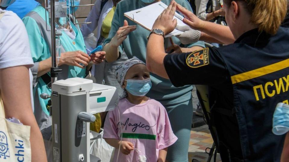 A psychologist gestures to a little girl at the site of a missile strike on the 'Okhmadyt' children's hospital in Kyiv, Ukraine, 08 July 2024, amid the Russian invasion.