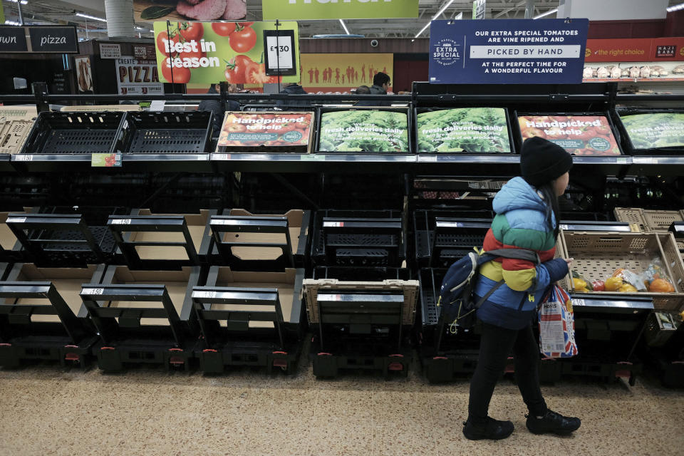 Una niña camina frente a estantes vacíos de la sección de frutas y verduras de un supermercado de la cadena Asda en el este de Londres, el sábado 25 de febrero de 2023.Durante las últimas dos semanas la gente en Reino Unido ha tenido que racionar las verduras básicas para sus ensaladas debido a la escasez de hortalizas frescas. (Yui Mok/PA vía AP)