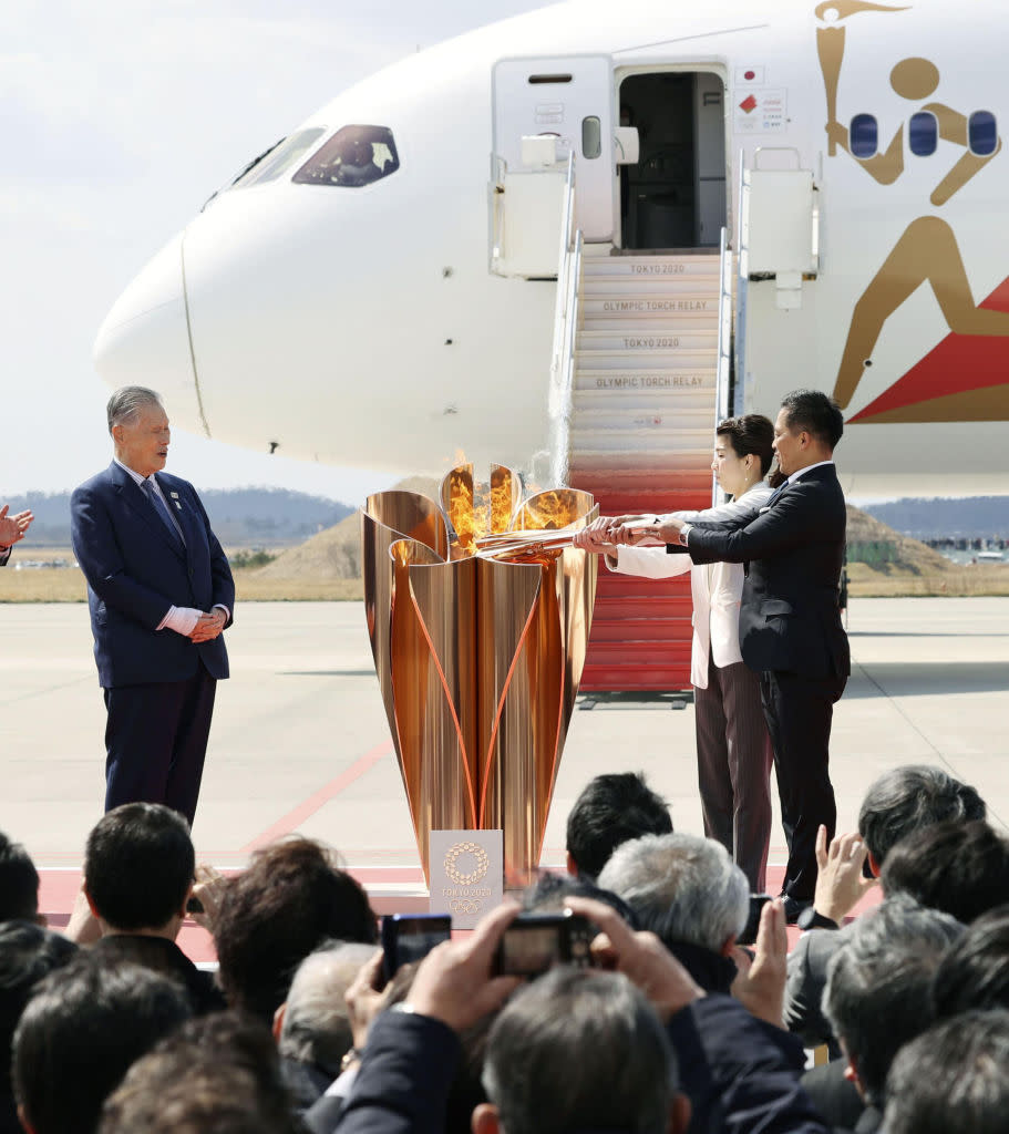 MIYAGI, March 20, 2020 . Olympic gold medalists Tadahiro Nomura ,1st R, and Saori Yoshida ,2nd R, light up the Olympic cauldron during the Olympic flame arrival ceremony in Miyagi of Japan, on March 20, 2020. The Olympic flame arrived in Japan on March 20. (Kyodo News/Handout to Xinhua via Getty)