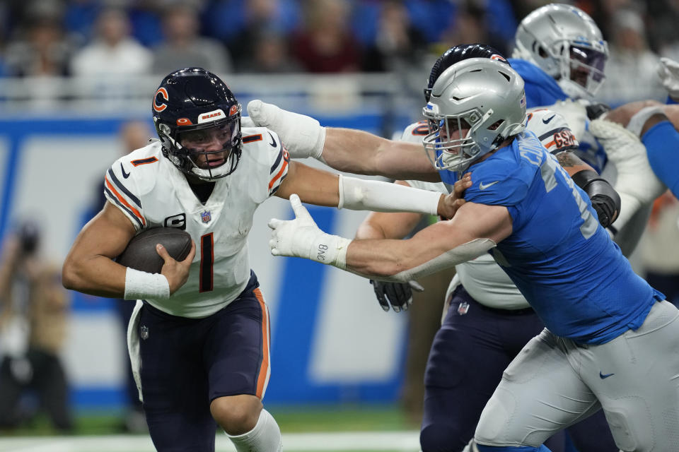 Detroit Lions defensive end John Cominsky (79) reaches Chicago Bears quarterback Justin Fields (1) during the second half of an NFL football game, Sunday, Jan. 1, 2023, in Detroit. (AP Photo/Paul Sancya)