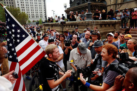 A man argues with a Trump supporter carrying a U.S. flag near the Republican National Convention in Cleveland, Ohio, July 21, 2016. REUTERS/Lucas Jackson