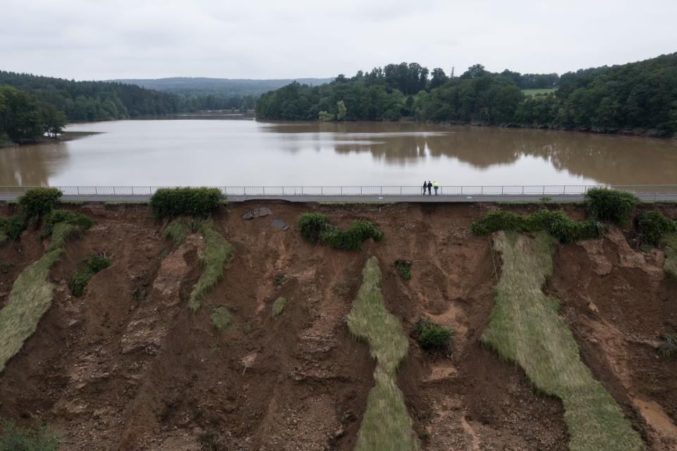 An aerial view shows people as they inspect the emptying of the damaged Steinbach hydrolic dam in Euskirchen, western Germany, on July 16, 2021, after heavy rain hit parts of the country, causing widespread flooding. - The death toll from devastating floods in Europe soared to at least 126 on July 16, most in western Germany where emergency responders were frantically searching for missing people. (Photo by SEBASTIEN BOZON / AFP) (Photo by SEBASTIEN BOZON/AFP via Getty Images)