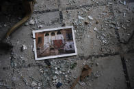 A photo rests among broken glass on the floor of the Sursock Palace, heavily damaged after the explosion in the seaport of Beirut, Lebanon, Friday, Aug. 7, 2020. The Sursock palace, built in 1860 in the heart of historical Beirut on top of a hill overlooking the now-obliterated port, is home to beautiful works of arts, Ottoman-era furniture, marble and paintings from Italy — the result of more than three long-lasting generations of the Sursock family. (AP Photo/Felipe Dana)
