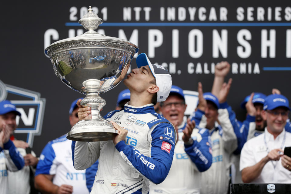 NTT IndyCar Series winner Alex Palou, center, celebrates with the trophy after taking fourth place in an IndyCar auto race at the Grand Prix of Long Beach, Sunday, Sept. 26, 2021, in Long Beach, Calif. (AP Photo/Alex Gallardo)