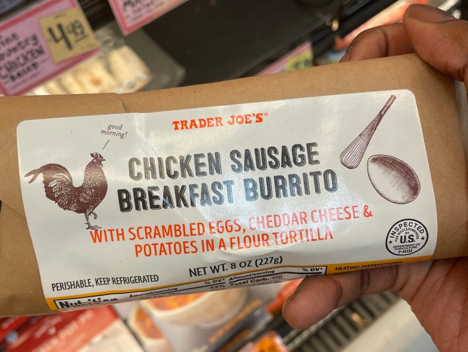 The writer holds a package of a chicken-sausage breakfast burrito