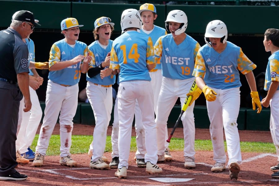 El Segundo, Calif.’s Brody Brooks (14) is greeted by teammates after hitting a solo home run off Needville, Texas’ DJ Jablonski during the first inning of the United States Championship baseball game at the Little League World Series tournament in South Williamsport, Pa., Saturday, Aug. 26, 2023. (AP Photo/Gene J. Puskar)