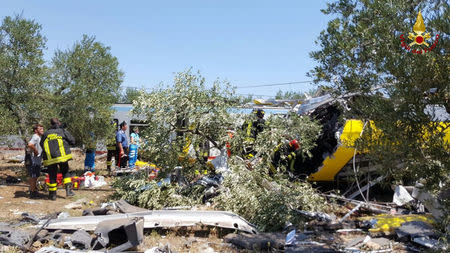 Firefighters work at the site where two passenger trains collided in the middle of an olive grove in the southern village of Corato, near Bari, Italy, in this handout picture released by Italian Firefighters July 12, 2016. Italian Firefighters/Handout via Reuters